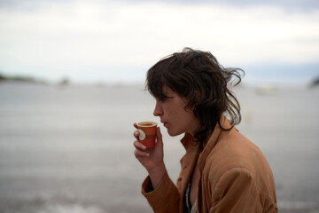 Drinking From a Cup by the Serene Seaside at Dusk