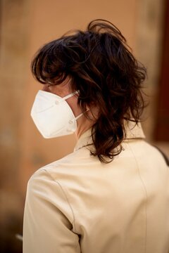 Individual Wearing a Mask in a Public Space During Daytime