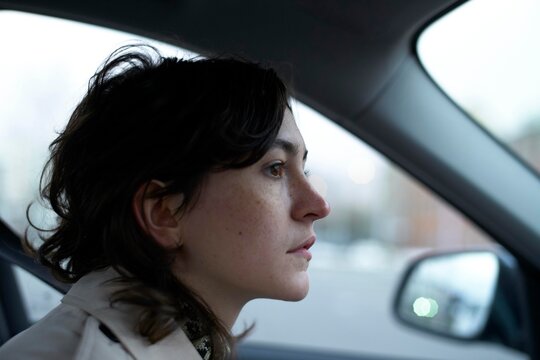 Woman Driving in a Car During Early Dusk Looking Thoughtful