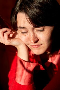 Woman Enjoying Warm Sunlight in Cozy Indoor Setting