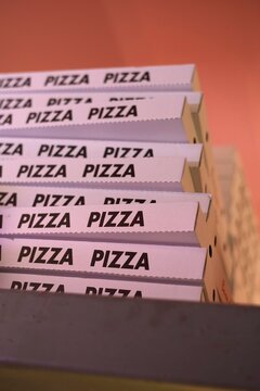 Stacked pizza boxes in a warm setting ready for delivery or takeout