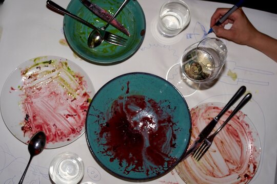 Dining table aftermath reveals colorful empty plates and glasses