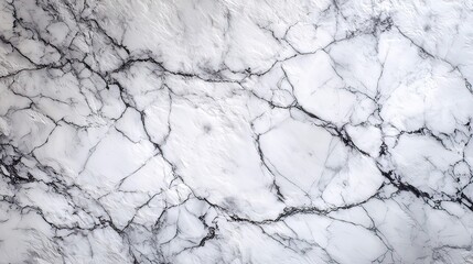 a close up view of a marble countertop with a prominent veining pattern. the surface is speckled with darker areas, including black and grey patches interspersed throughout the lighter base color