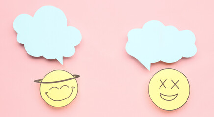Happy paper faces with blank speech bubbles on pink background