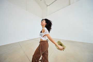 Joyful woman poses in minimalist indoor space with flowing hair