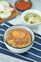Steamed rice with chicken and egg, served with cracker and chilli,  comfort food for breakfast