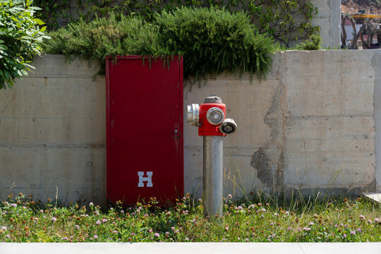 Red Fire Hydrant and Cabinet on Concrete Wall
