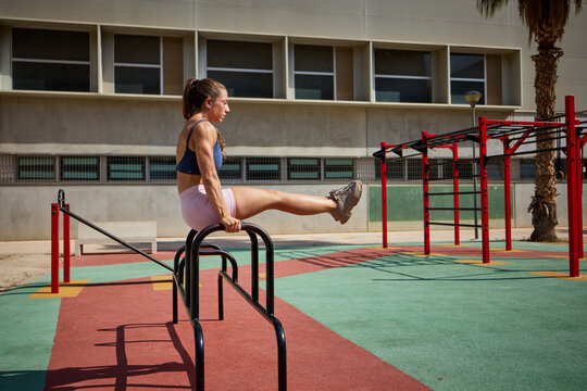 Woman doing calisthenics at an outdoor fitness park