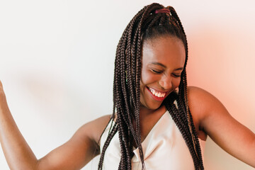 Portrait photo of happy dancing African American woman with braids