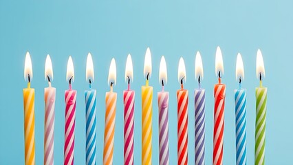 Row of colorful birthday candles with flickering flames, isolated on a soft blue background.