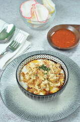 Rice porridge served with shredded with shredded Cchicken, cakwe, crackers, and chilli