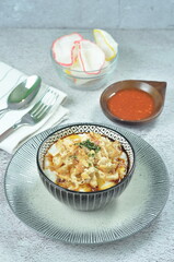 Rice porridge served with shredded with shredded Cchicken, cakwe, crackers, and chilli