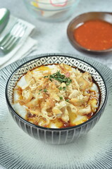 Rice porridge served with shredded with shredded Cchicken, cakwe, crackers, and chilli