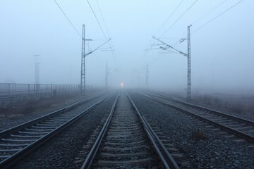 Obraz premium Foggy Train Tracks Converging to Distant Light