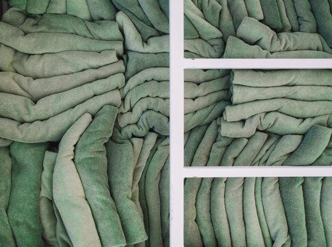 Soft green towels neatly arranged on shelves in a tidy setting