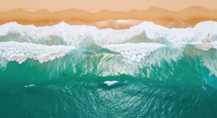 Aerial view of surfers riding waves in a vibrant ocean against a sandy beach backdrop