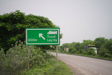 truck lay-by road sign, highway truck parking ahead, roadside green direction board, transportation truck stop sign stock photo.
