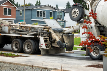 Cement mixer truck and cement pumper truck set up to feed fresh cement to boom arm to pump fresh...