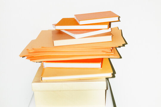 Pile of orange papers and books in office with hard direct flashlight