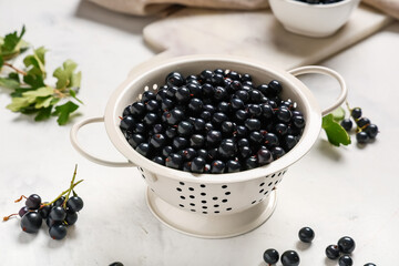 Colander with fresh black currants on white background, closeup