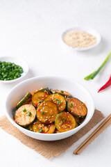 Korean cucumber salad (Oi muchim) in bowl on white background, Korean side dish