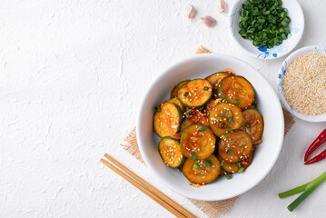 Top view of Korean cucumber salad (Oi muchim) in bowl on white background, Korean side dish
