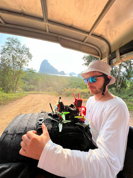 Man with FPV drones in tropical adventure truck