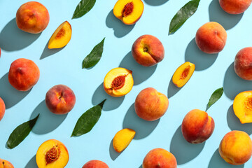 Sweet ripe peaches and leaves on blue background