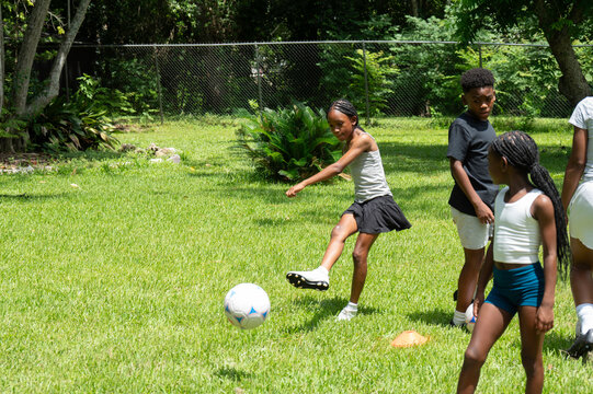 Fototapeta Family enjoying quality time in the backyard playing the sport soccer