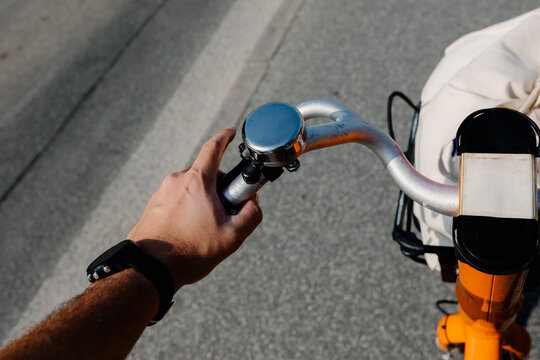 Anonymous man's hand ringing the bell of a rental bicycle