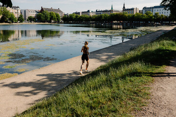 Fitness tourist jogging leisurely on the shores of Lake Sortedams So