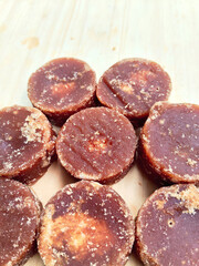 Natural Palm Sugar Discs on a Rustic Wood Board
