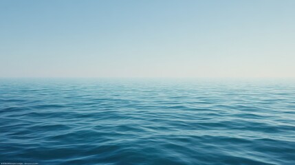 Fototapeta premium Calm Turquoise Ocean Water Ripples Under a Pale Blue Sky, Tranquil Seascape Scenery