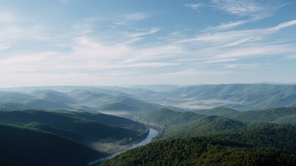 Fototapeta premium Forested mountain range stretches into the distance under a bright sky and thin clouds