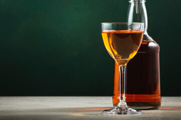 French apple brandy in glass on dark green background