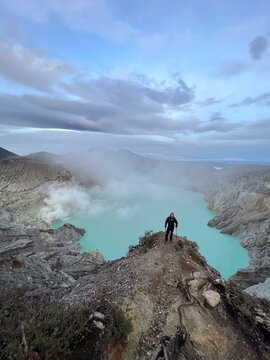 Hiker above turquoise crater lake
