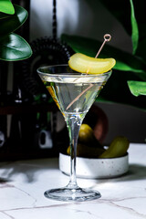 Cajun Martini alcohol cocktail drink with vodka, jalapeno pepper, dry vermouth and pickle with bar tools