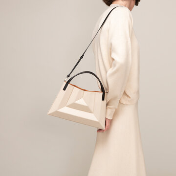 Elegant Beige Handbag Styled Against Minimalist Cream Background
