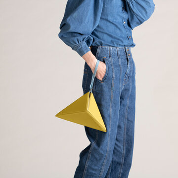 Person Wearing Stylish Denim Outfit and Holding Unique Yellow Tr