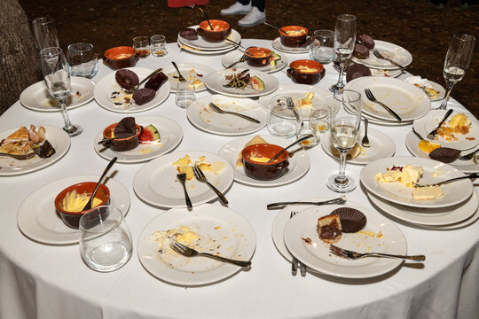 Dinner Party Aftermath With Empty Plates and Dessert Remnants