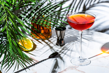 vibrant red cocktail featuring whiskey, port wine, and bitters on a stylish bar table