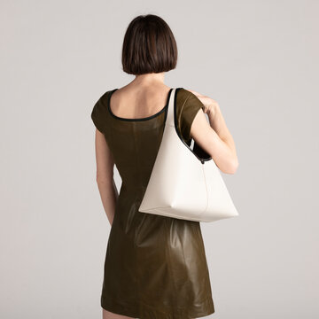 Fashionable Individual Carrying a Sleek White Bag in Stylish Att