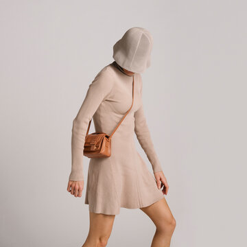 Stylish Beige Outfit With Accessory Showcased in a Minimalist St