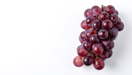 Fototapeta premium A vibrant bunch of plump, juicy grapes in shades of deep purple and green, resting elegantly against a clean, bright white background.