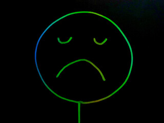 sad face neon on black background	
