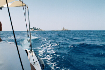 Boat Heading Towards Small Island in Ocean
