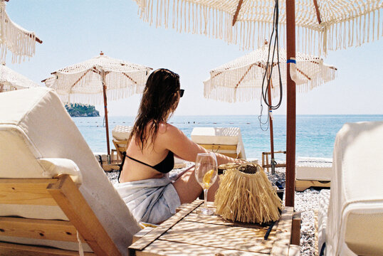 Woman Relaxing on Beach Lounger with Drink
