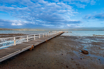 Obraz premium Photograph of an old wooden jetty in Lake Illawarra near Warrigal in the Illawarra region on the south coast of New South Wales, Australia. 