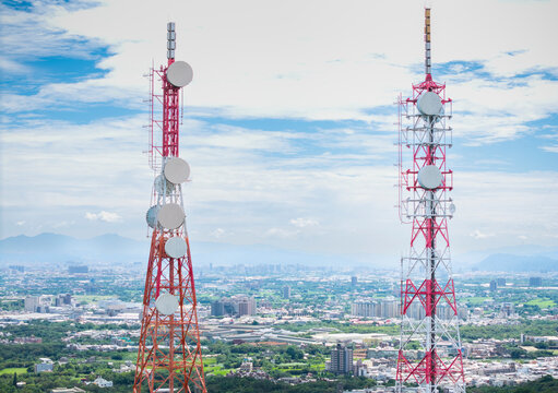 Telecommunication Towers Above Urban City Landscape