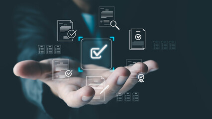 A businessman's hand presents a virtual interface with a checkmark icon, symbolizing document approval, quality assurance, and business compliance technology.